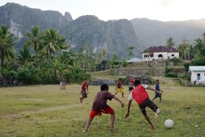 Boys play soccer at the feet of Matebien. This community chose interventions of fish farming and gardening vegetables high in vitamins. 